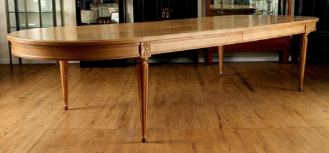 FRENCH LOUIS XVI STYLE BEECH DINING TABLE: An oversized French Louis XVI style Beech dining table. Having three 23" skirted leaves and two center legs allowing table to extend to 208". Ht: 30.5" Wd: 138" Dpth: 50"