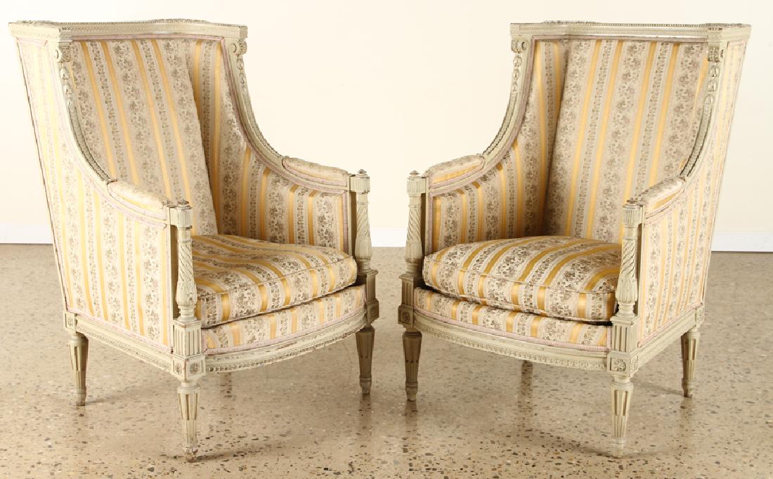 PAIR FRENCH CARVED UPHOLSTERED BERGERE CHAIRS: A pair of French Louis XVI style bergere chairs nicely upholstered in silk with down seat cushion circa 1940. Having extensively carved frame. Ht: 38.5" Wd: 25" Dpth: 30"