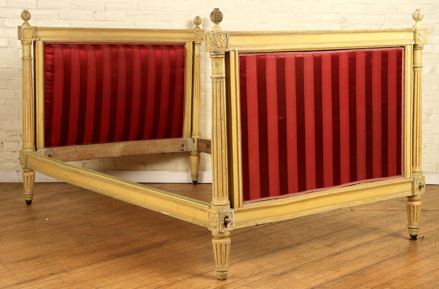 FRENCH PAINTED AND CARVED BED CIRCA 1900: A painted and upholstered French bed having carved finials resting on carved and fluted columns circa 1900. Ht: 45" Wd: 51" Dpth: 78"