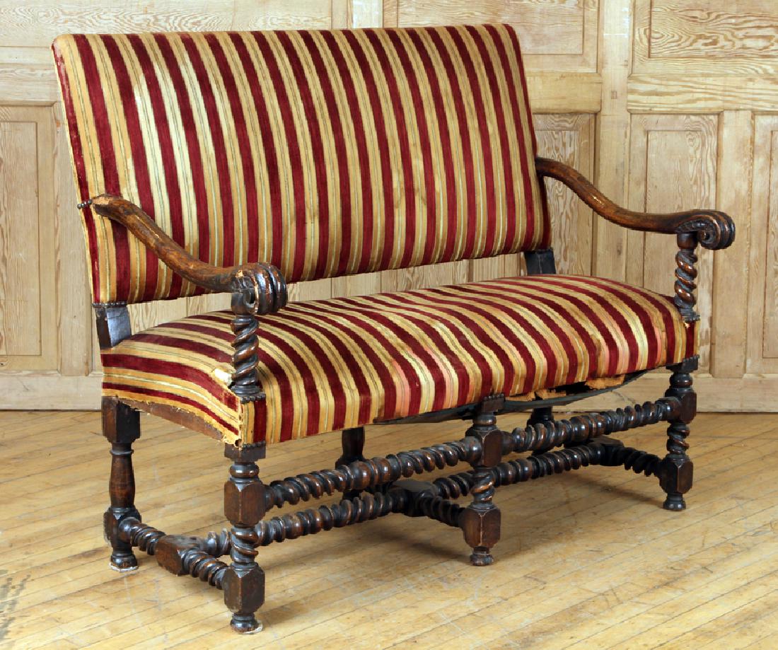 18TH CENT. SPANISH WALNUT OPEN ARM SETTEE: An eighteen century Spanish walnut open arm settee having an upholstered back and seat resting on a twisted stretcher base. Ht: 42" Wd: 50" Dpth: 29" Seat: 20"