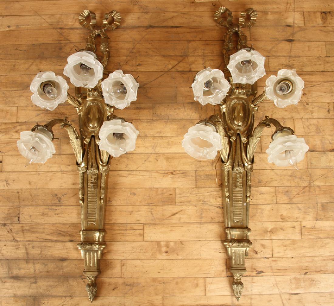 PAIR CAST BRONZE 5 ARM FRENCH STYLE WALL SCONCES: A pair of cast bronze five arm French style wall sconces having ribbon motif and glass shades. Ht: 40" Wd: 13" Dpth: 12"