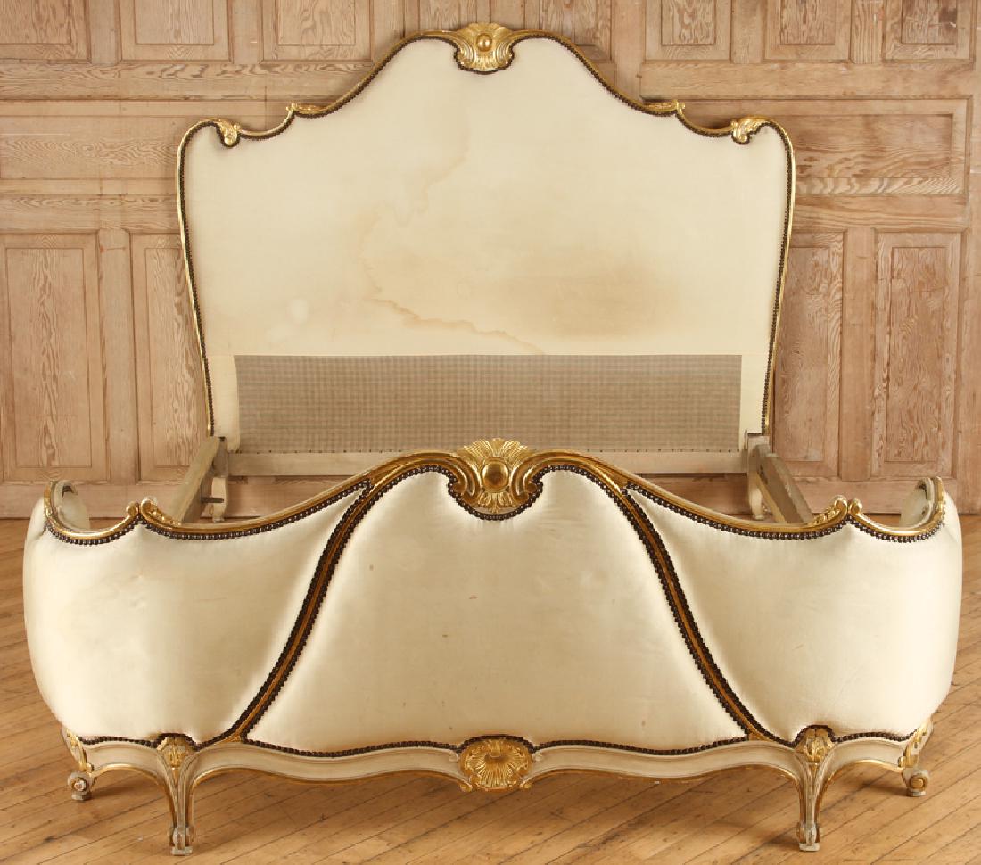 FRENCH LOUIS XV STYLE CARVED GILT QUEEN SIZE BED: A French Louis XV style carved and gilt upholstered queen size bed circa 1940. The shaped headboard trimmed in wood and having conforming foot board and curved ends. The rails having shell carvings. I