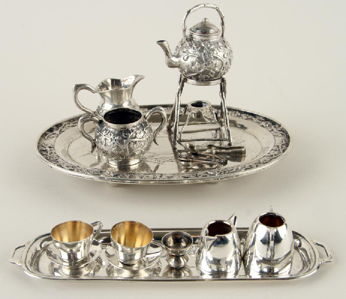 TWO SILVER MINIATURE TEA SERVICES 6.23 TROY OZ: A lot of two silver miniature tea services, total weight: 6.23 troy oz. To include: A four piece set with hot water kettle on stand An English set with handled tray
