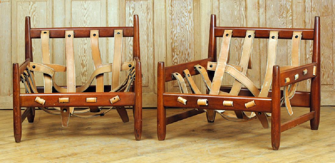 PAIR BRAZILIAN WOOD LEATHER ARM CHAIRS: A pair of Brazilian wood and leather arm chairs attributed to Sergio Rodriguez. Ht: 27.5" Wd: 29" Dpth: 29.5" Seat: 11"