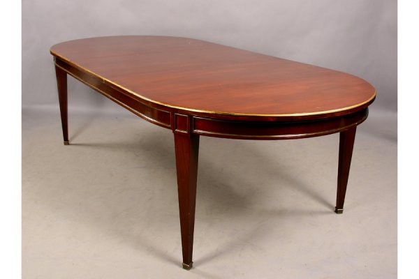 Jansen mahogany bronze mounted dining table: Good Jansen mahogany dining table with bronze mounted top circa 1940. The skirt having a bronze bound design along with bronze squares" at the top of each leg along with one leaf measuring 24". Ht: 30