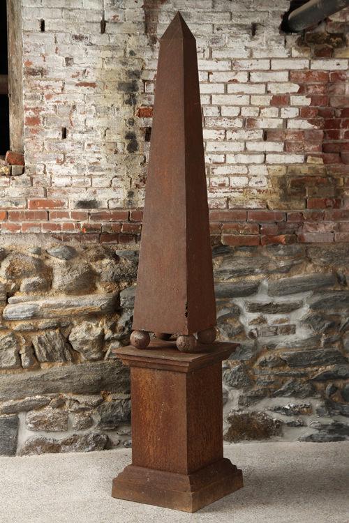 TWO PIECE IRON OBELISK ON BASE WITH BALL FEET: A two piece iron obelisk on base with ball feet. Base only: 28.5" x 18" x 18" Top only: Ht- 63" Ht: 91.5" (overall)