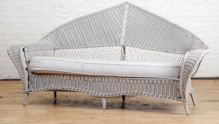 WICKER SOFA W/ PEAKED BACK & LOOSE CUSHION C.1920: A wicker sofa having a peaked back and loose cushion seat circa 1920. Ensuite Ht: 40" Wd: 78" Dpth: 26" Seat: 18"