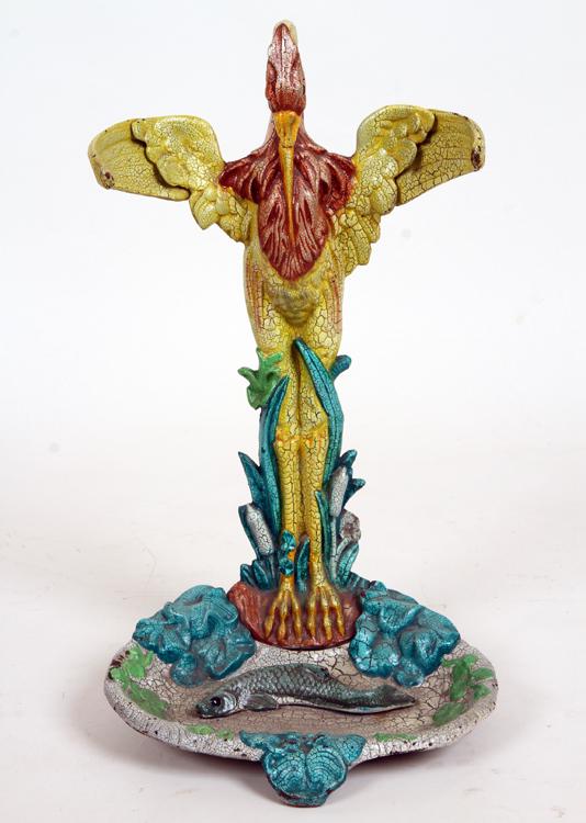 EGRET FORM CAST IRON POLYCHROME UMBRELLA STAND: An egret form cast iron polychrome umbrella stand having a swimming fish in the pan. Ht: 22" Wd: 12" Dpth: 11"
