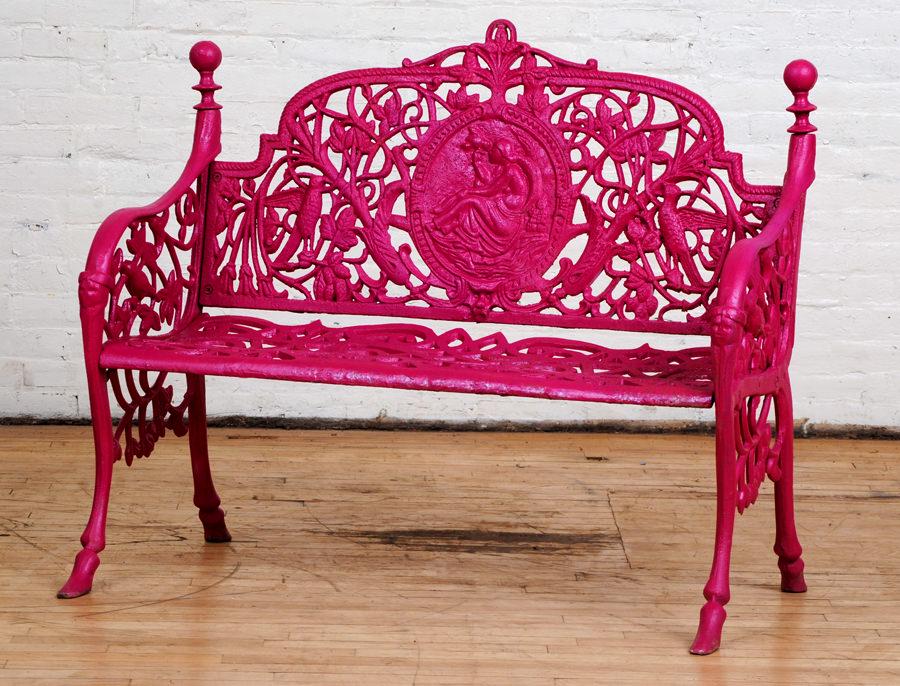 PAINTED CAST IRON GARDEN BENCH MEDALLION BACK: A painted cast iron garden bench having medallion back with a seated figure holding a bird. Ht: 35" Wd: 40.5" Dpth: 24"