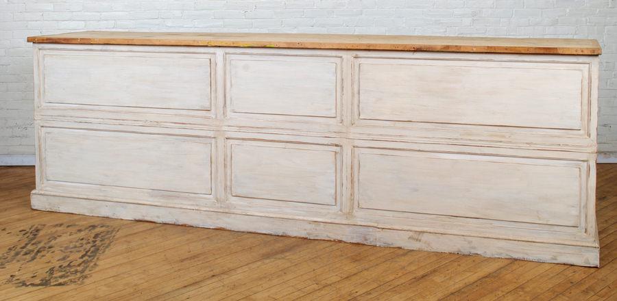PAINTED STORE COUNTER RAISED PANEL FRONT: A painted store counter having raised panel front and open back. Ht: 43" Wd: 128.5" Dpth: 25"