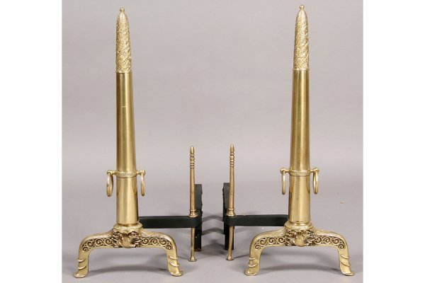 Pair of polished brass andirons in the A: Pair of polished brass andirons in the Art Nouveau taste circa 1920. Having stylized feather and bead decorated tops on a conical shaft with attached rings raised on flared feet. Ht: 28 Width: 10" Dep