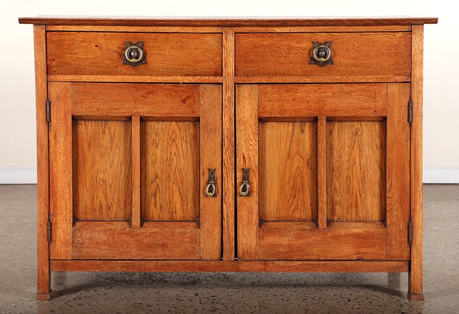 ENGLISH ARTS AND CRAFTS OAK SERVER BRASS 1880: An English Arts and Crafts oak server having two drawers over two recessed panel doors with brass hardware circa 1880. Ht: 36" Wd: 52" Dpth: 21.75"