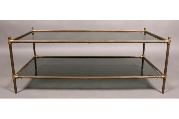 MODERN 2 TIER BRASS GLASS COFFEE TABLE: Mid century modern two tiered coffee table with brass corner finials and reeded frame circa 1960. Smoked glass top and shelf. Ht: 18" Width: 47" Depth: 25.5" ***PLEASE NOTE: All property shall be paid