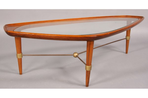 MODERN FREE FORM SHAPED COFFEE TABLE GLASS TOP: Mid century modern free form shaped coffee table with inset glass top circa 1960. Supported on tapered and turned legs with bronze stretcher with central ball. Ht: 15.5" Width: 54.5" Depth: 25.5" ***