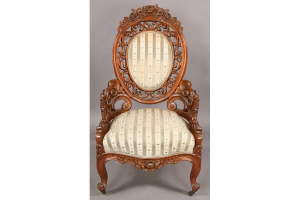 ANTIQUE VICTORIAN CARVED ORNATE PARLOR CHAIR: American Victorian carved walnut parlor chair with highly ornate floral and scroll pierced oval back, floral carved sides and shaped legs circa 1870. Having an upholstered central back panel and seat,
