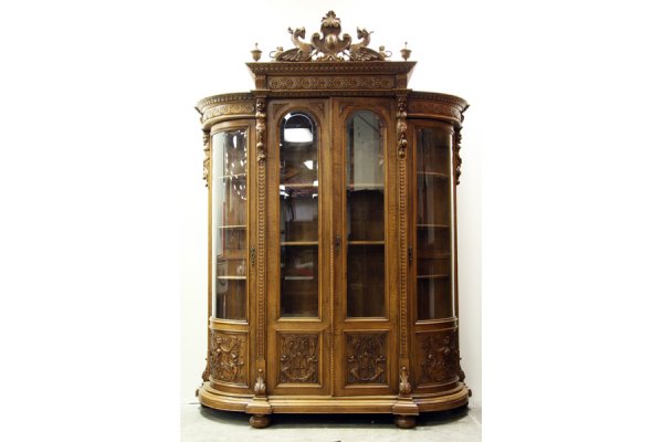 A very good Victorian carved walnut china cabinet w: A very good Victorian carved walnut china cabinet with highly carved stepped cornice over four beveled glass doors circa 1870. All decorated by carved figures, griffin scroll work and fruit carved pan