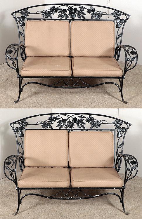 PAIR WROUGHT IRON SETTEES WITH CUSHIONS C.1960: A pair of wrought iron settees with cushions circa 1960. Having fruit and leaf decoration. Ht: 37.5" Wd: 60" Dpth: 35" Seat: 14.25"