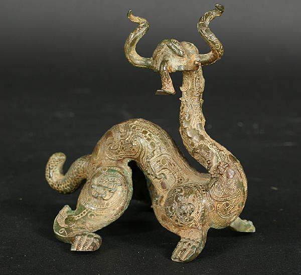 LATE SHANG DYNASTY ANTIQUE CHINESE BRONZE DRAGON: Finely crafted late Shang Dynasty Chinese bronze dragon ornament having curling horns and a long protruding tongue circa 13th-11th B.C. Ht: 4" Width: 4"