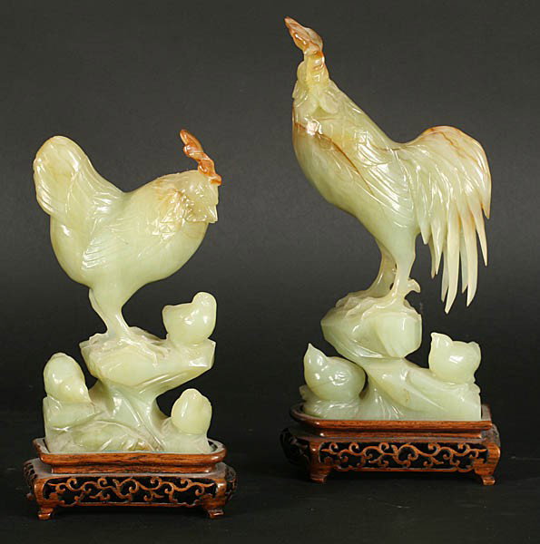 PR CARVED ASIAN HARDSTONE ROOSTER HEN FIGURES: Pair of carved Asian hardstone figures of a rooster and hen with chicks mounted on carved fitted wood stands. Mid twentieth century. Ht: 10.5" Width: 5" Depth: 2.25"