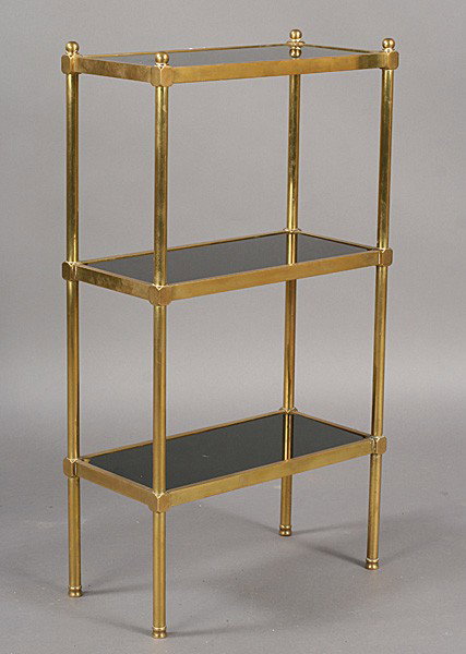 MID CENT MODERN BRASS BLACK GLASS ETEGERE SHELF: Mid century modern brass etegere having inset black glass shelves circa 1960. Ht: 36" Width: 19.5" Depth: 10"