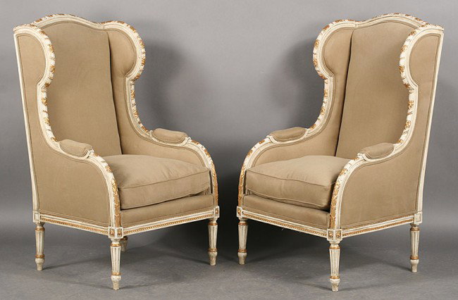 PR FRENCH LOUIS XVI BERGERES A OREILLES ARM CHAIR: Pair of French Louis XVI bergeres a oreilles with carved giltwood and painted frames and turned and fluted legs circa 1940. Having upholstered backs and loose cushion seat. Ht: 46" Width: 27.5" Depth: