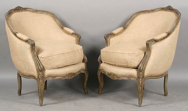PR FRENCH LOUIS XVI STYLE VINTAGE BERGERES CHAIRS: Pair of French Louis XVI style carved and painted bergeres having arched backs, loose cushion seats and cabriole legs circa 1940. Ensuite with the previous lot. Ht: 36" Width: 25" Depth: 26"