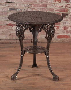 POLISHED CAST IRON GARDEN TABLE WITH MASKS C.1900: A polished cast iron garden table with female masks circa 1900. Ht: 27" Dia: 23.5"