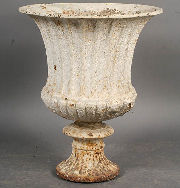 A French antique cast iron campana form garden ur: A French antique cast iron campana form garden urn with a fluted and melon form bowl supported on a socle and fluted base. Dimensions: Ht: 28" Diameter: 23"
