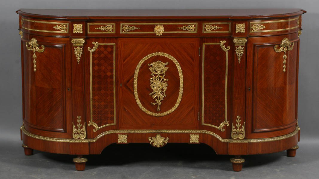 FRENCH BELLE EPOCH BRONZE MOUNTED SIDEBOARD: A very good antique French Belle Epoch Louis XVI style bronze mounted sideboard circa 1900. Having a central door with satinwood inlay and gilt bronze decoration, flanked by two curved doors with chev
