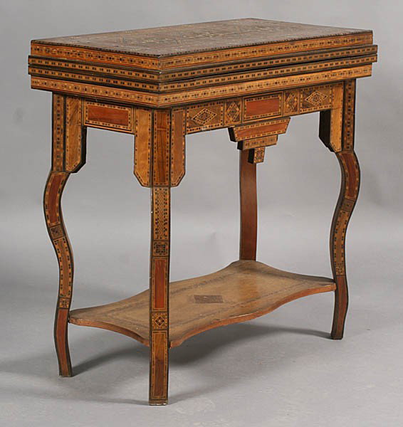 LABELED MOROCCAN SATINWOOD MAHOGANY GAMES TABLE: A good labeled antique damascene, elaborately inlaid mother of pearl, satinwood and mahogany flip top games table circa 1890. The table having both chess and backgammon boards, supported on shaped leg