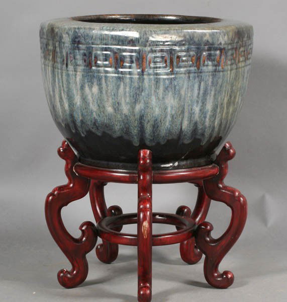 ASIAN EARTHENWARE MULTICOLORED GLAZE PLANTER: An Asian earthenware multicolored glaze planter on ornate wood stand. Ht: 23" Width: 18" Depth: 18"