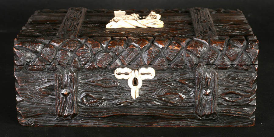 ANTIQUE CARVED BLACK FOREST BOX APPLIED BONE: A nicely carved Black Forest box with ornate carved "wood plank" surfaces and applied bone decoration circa 1890. Bone carving depicts a young man with a trained bear in tow and bough escutcheon. Ht: 