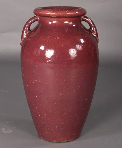 LR 2 HANDLED OXBLOOD GLAZED POT C.1930: A large two-handled oxblood glazed earthenware vessel with rolled rim and bulbous body circa 1930. Unknown maker. Ht: 28" Width: 15"