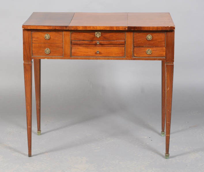 19TH CEN. FRENCH BRONZE BEAD TRIM DRESSING TABLE: A nineteenth century French Louis XVI style bronze bead trimmed dressing table. Having a flip top with interior mirror and compartments over two drawers and a slide. Supported on tapered legs. Ht: 21"