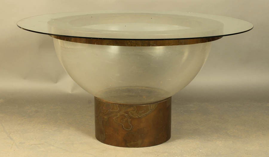 MID CENTURY MODERN DINING TABLE C.1970: A mid century modern dining table having a glass top over an acrylic and brass framed bowl form base on a round platform circa 1970. Ht: 30" Dia: 58"