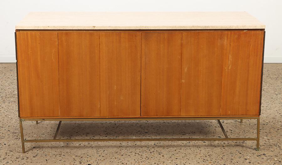 PAUL MCCOBB DRESSER BY CALVIN HAVING A TRAVERTINE: Paul Mccobb dresser by Calvin having a travertine top over accordian action doors opening to a fully fitted interior on a brass base. One of two. Ht: 34" Wd: 60" Dpth: 19"