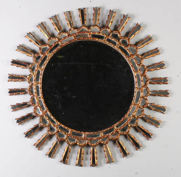 DECORATIVE SUNBURST MIRROR GILT FRAME: A decorative sunburst style mirror with gilt, carved wood and mirrored frame. Dia: 24"