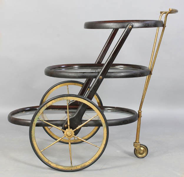 ALDO TURA STYLE VINTAGE 3 TIERE SERVING CART: A mid century modern Aldo Tura style three-tiered serving cart having graduated glass trays over spoked wheels circa 1960. Ht: 32" Width: 20" Depth: 35"