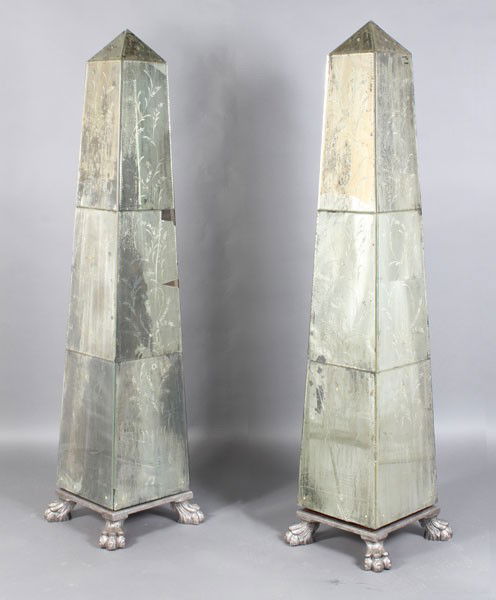 PAIR VENETIAN LARGE ETCHED MIRRORED OBELISKS: A pair of Venetian style large etched mirrored obelisks. Each having distressed and etched panels. Raised on carved wood bases with stylized paw feet. Ht: 72" Width: 17.5" Depth: 17.5"