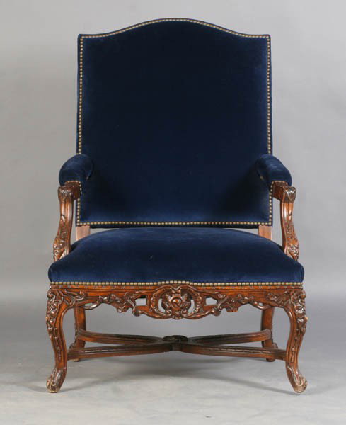 RALPH LAUREN CARVED LIBRARY CHAIR: A Ralph Lauren carved and upholstered library chair with arched back, nailhead decoration, open arms and cabriole legs with shaped stretcher. Ht: 43.5" Width: 29" Depth: 25.5"