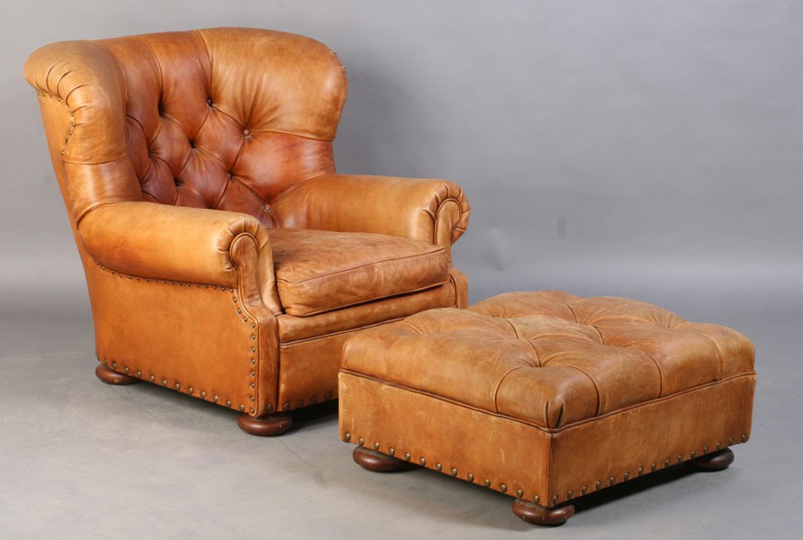 RALPH LAUREN LEATHER LIBRARY CHAIR & OTTOMAN: Ralph Lauren leather library chair having a rolled edge and tufted back over loose cushion. Lot includes a Ralph Lauren ottoman. Ht: 36" Width: 38" Depth: 35"