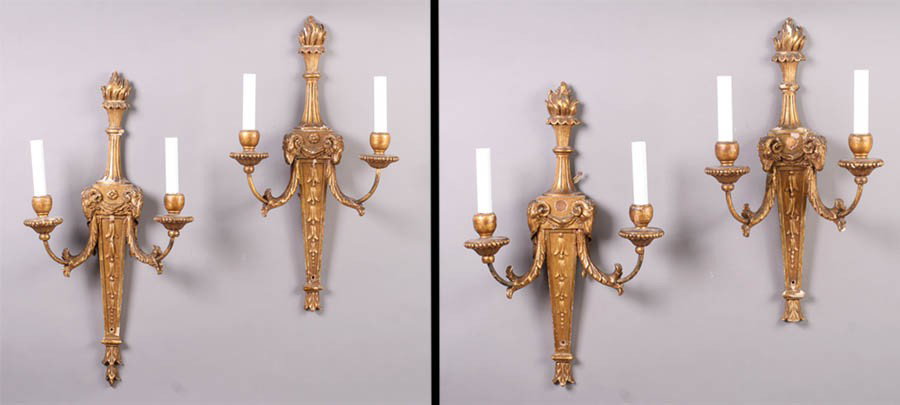 4 ANTIQUE ADAMS STYLE CARVED GILTWOOD SCONCES: Four carved and giltwood wall sconces in the Adams style circa 1910, the two-arm sconces having rams' heads and floral motifs. Ht: 24" Width: 12.5" Depth: 6"