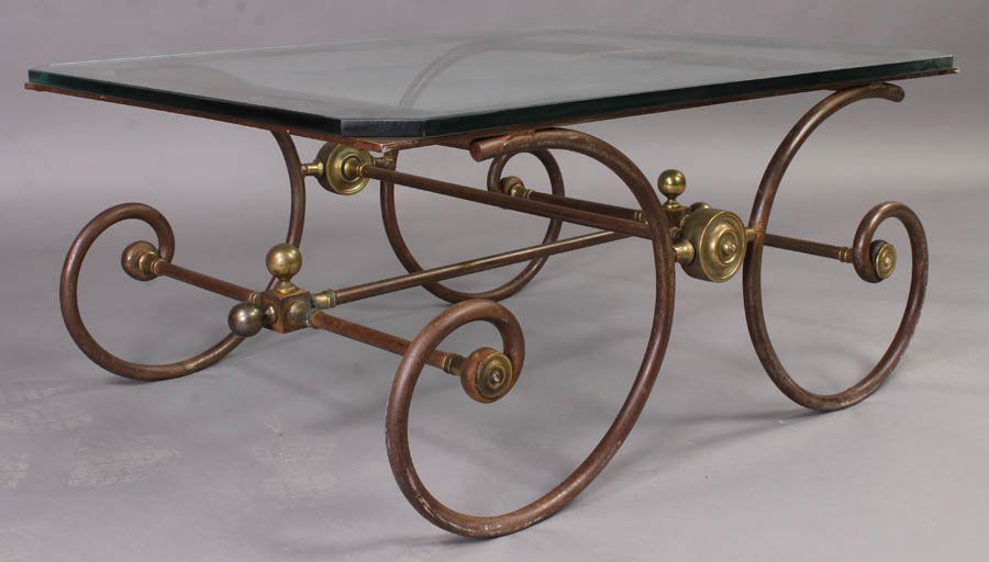 BRASS STEEL BAKERS TABLE COFFEE TABLE GLASS TOP: A brass and steel bakers table style coffee table having a glass top over scrolling legs with ball finials and cross stretcher circa 1950. Ht: 18.5" Width: 41" Depth: 31"