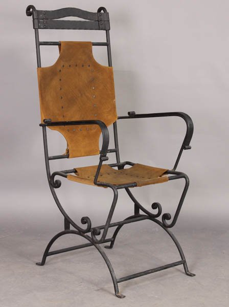 HI BACK MORGAN COLT STYLE LEATHER IRON ARM CHAIR: A high back wrought iron arm chair in the Morgan Colt style with leather sling back and seat on scroll decorated legs circa 1940. Ht: 46" Width: 21" Depth: 23"