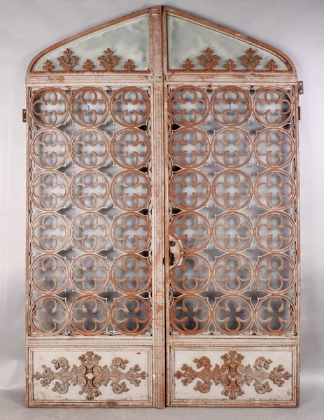 ANTIQUE GOTHIC IRON GLASS ENTRY DOORS: A very good pair of antique Gothic style entry doors each having glass transom and lower panels with applied decoration circa 1880. Ht: 94" Width: 62"