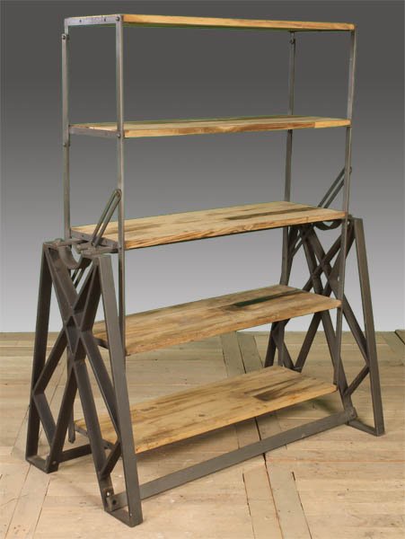 INDUSTRIAL METAL WOOD MECHANICAL BOOKSHELF: Industrial metal and wood mechanical bookshelf and table having bridge form sides with supporting wood shelves that transform into a table. Ht: 56" Width: 43" Depth: 23.5"