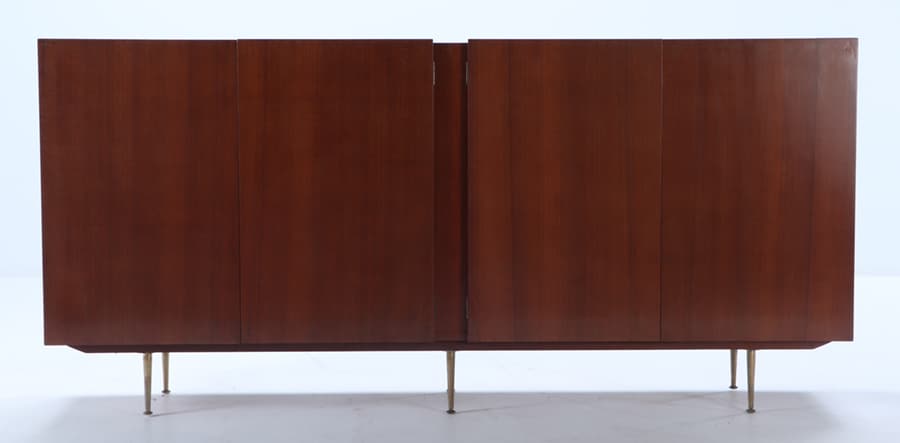 A MID CENTURY MODERN FOUR DOOR BAR CABINET OPENING TO REVEAL A MIRRORED BLONDE INTERIOR WITH DRAWERS: A mid century modern four door bar cabinet opening to reveal a mirrored blonde interior with drawers and pull out slide. Ht: 42" Wd: 88.75" Dpth: 16.75"