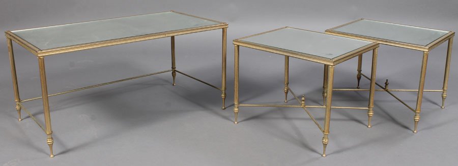 3 PC BRASS PLATED COFFEE TABLE MIRRORED: A three piece brass plated Empire style coffee table and two end tables, all having mirrored tops and vitruvian scroll decorated frame. Supported on turned legs with x-form stretcher. Ht: 17" Width: 3