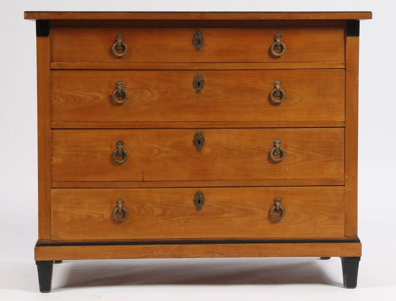 ANTIQUE BIEDERMEIER 4 DRAWER GILT BRONZE COMMODE: Biedermeier commode having four drawers with gilt bronze wreath pulls raised on ebonized tapered legs. Nineteenth century. Ht: 35.5" Width: 43" Depth: 23"