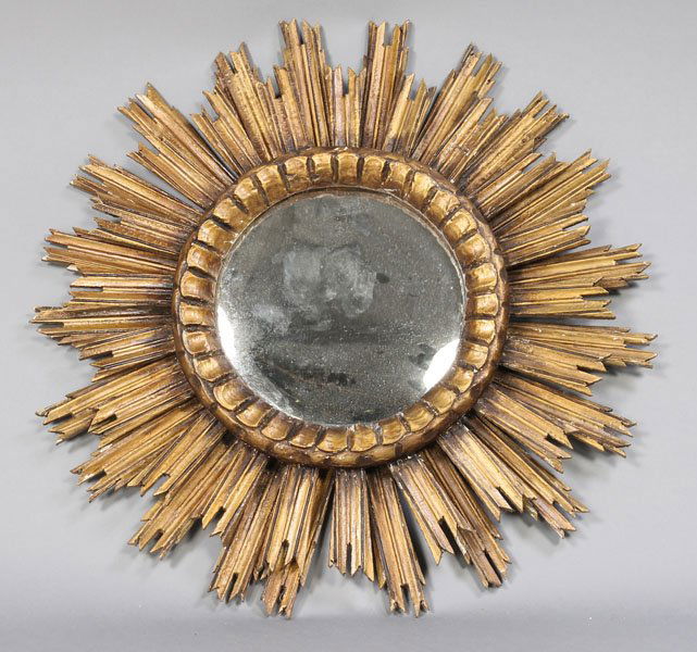 CONTINENTAL GILTWOOD CARVED SUNBURST MIRROR: A Continental giltwood carved sunburst mirror circa 1950. Dia: 24"